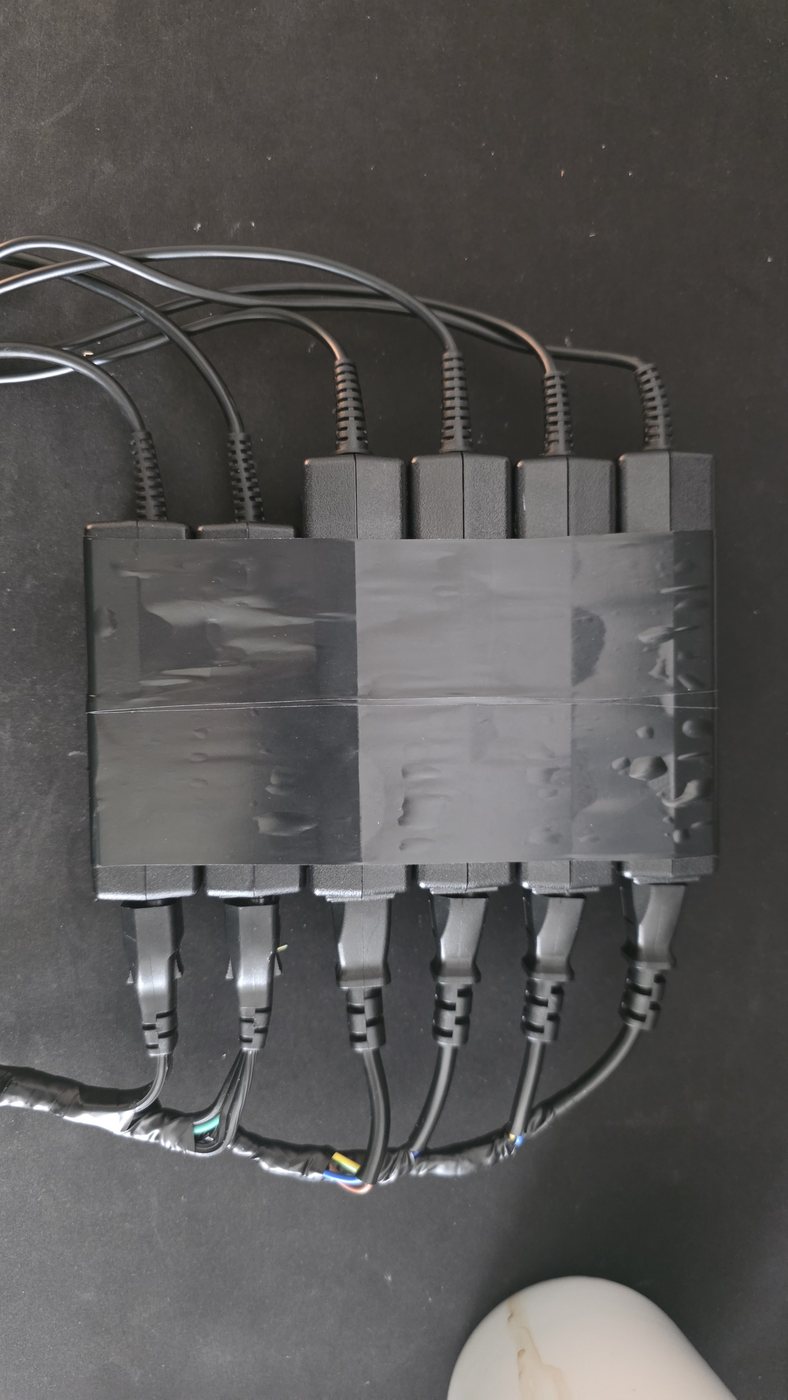 Six HP laptop-style power bricks taped together in a single bundle, each with its own mains lead and DC lead.